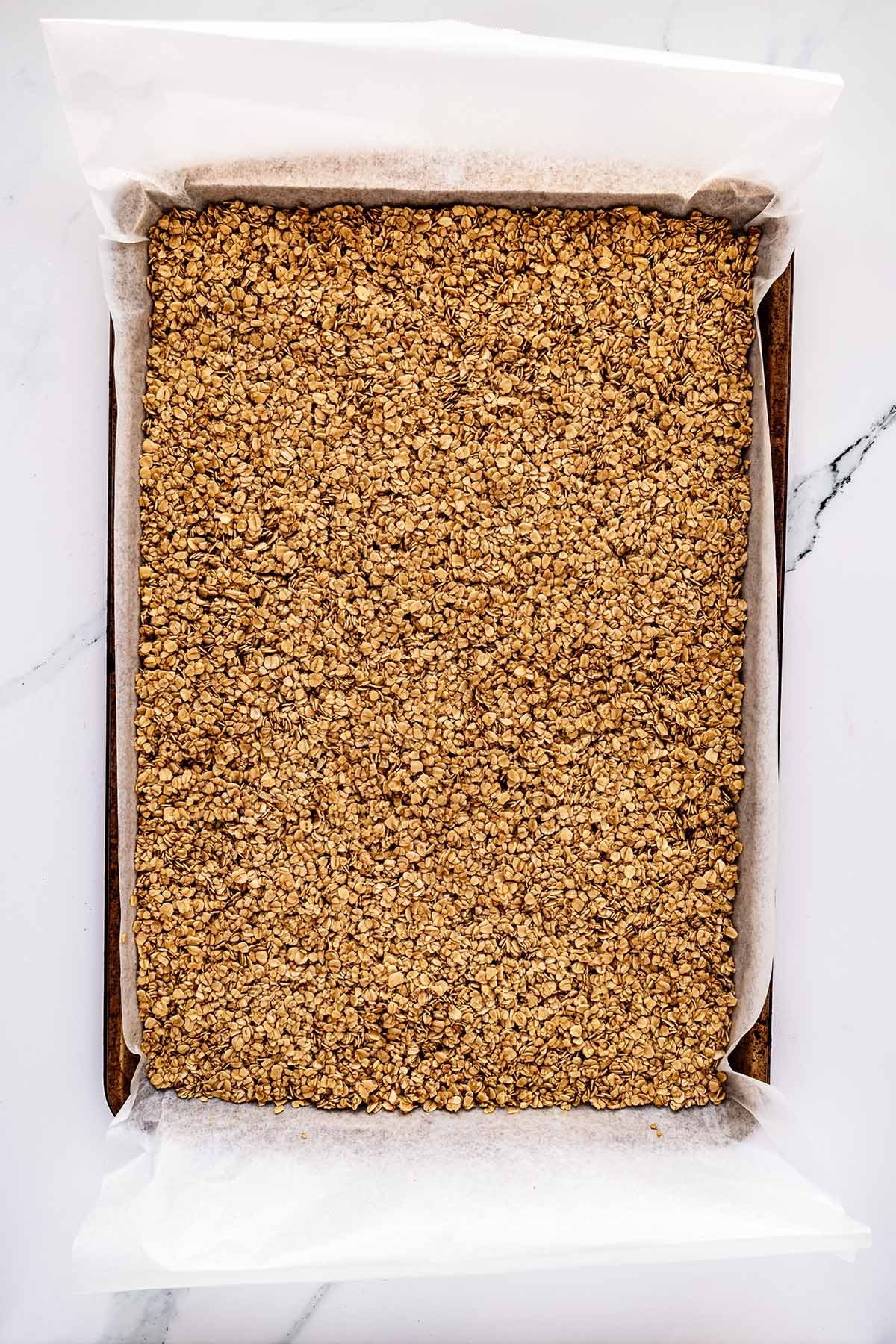 Overhead view of oat mixture in a baking sheet