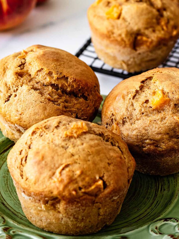 Close up of three peach muffins on a green plate