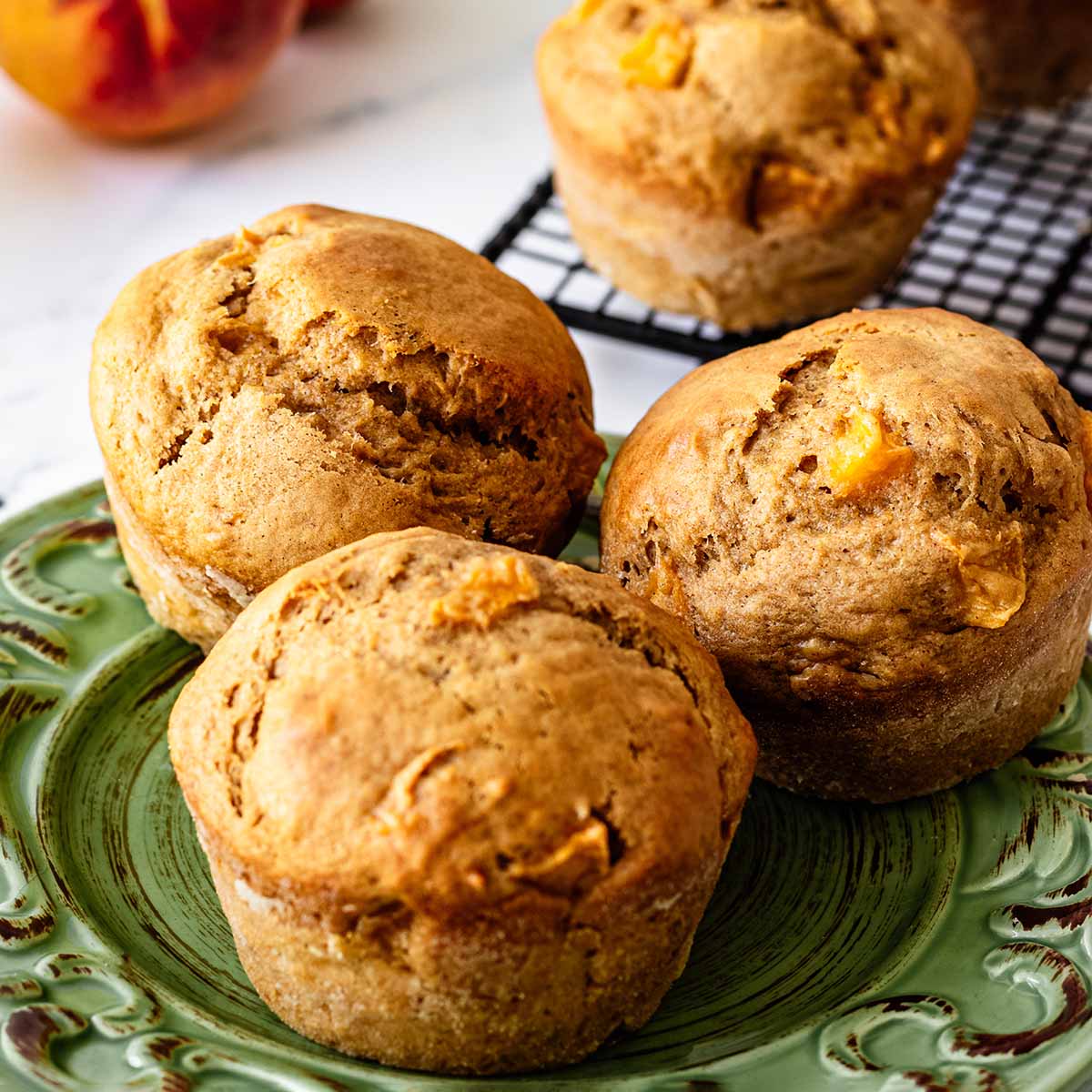 Close up of three peach muffins on a green plate