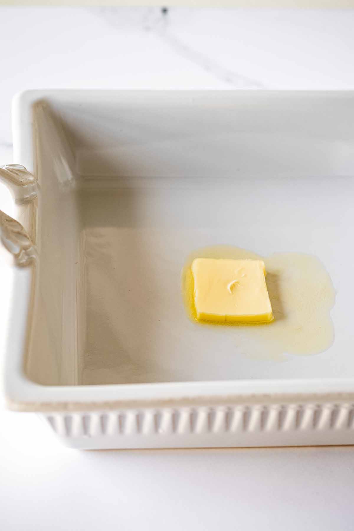 Pat of soft butter in a white baking dish