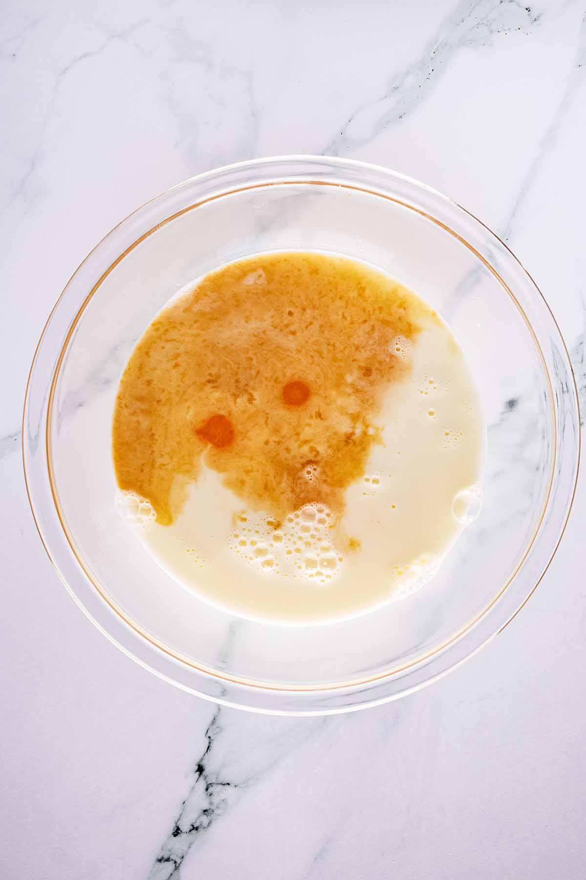 Overhead view of wet ingredients in a glass bowl