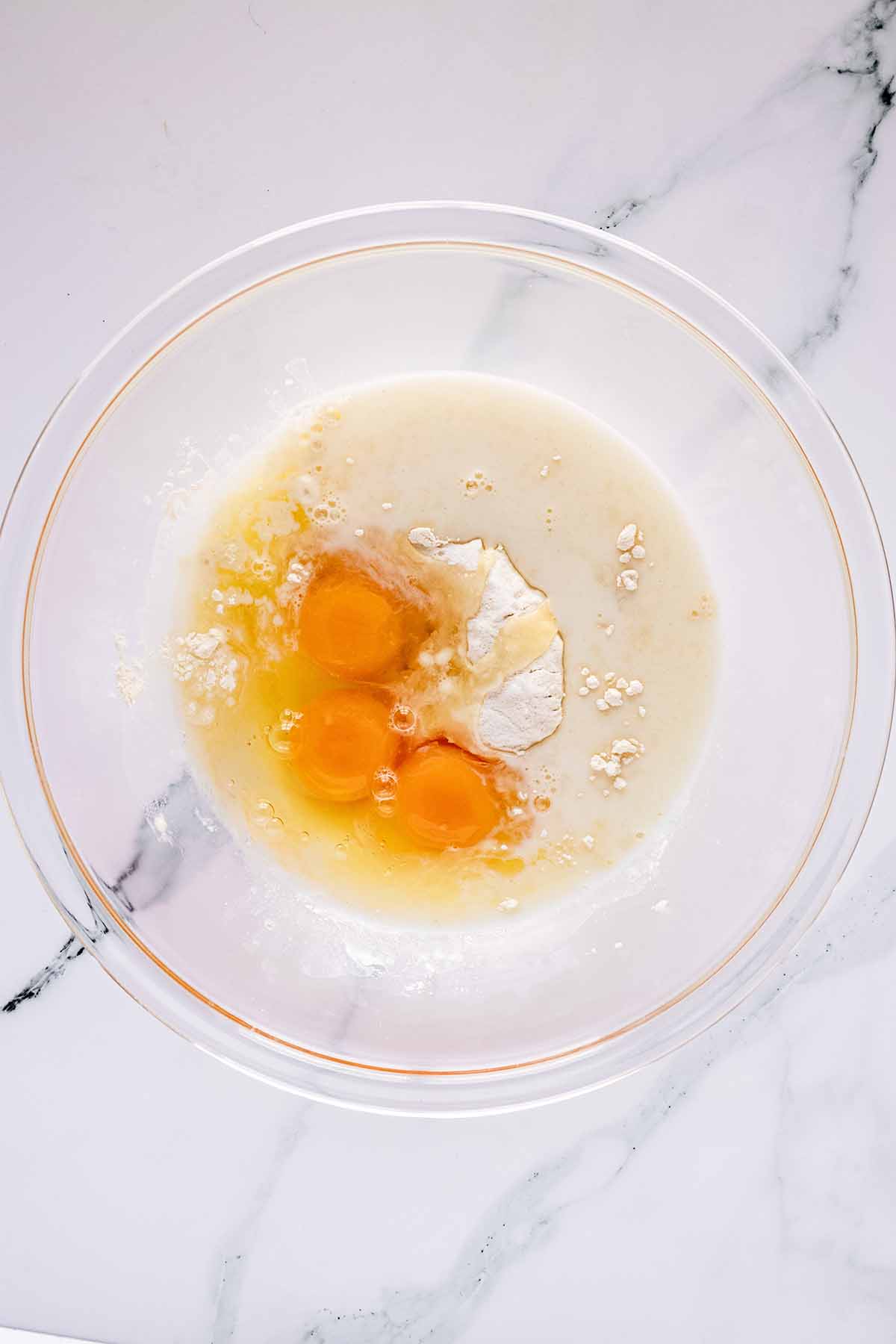 Overhead view of batter ingredients in a glass bowl