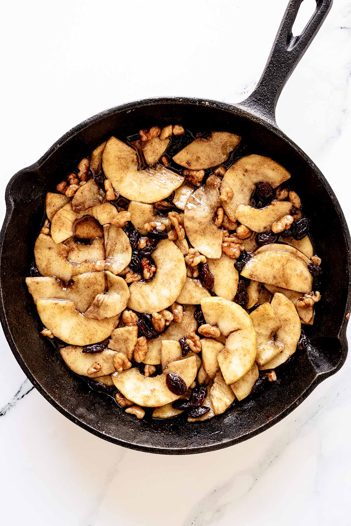 Overhead view of cooked apple mixture in a cast iron skillet