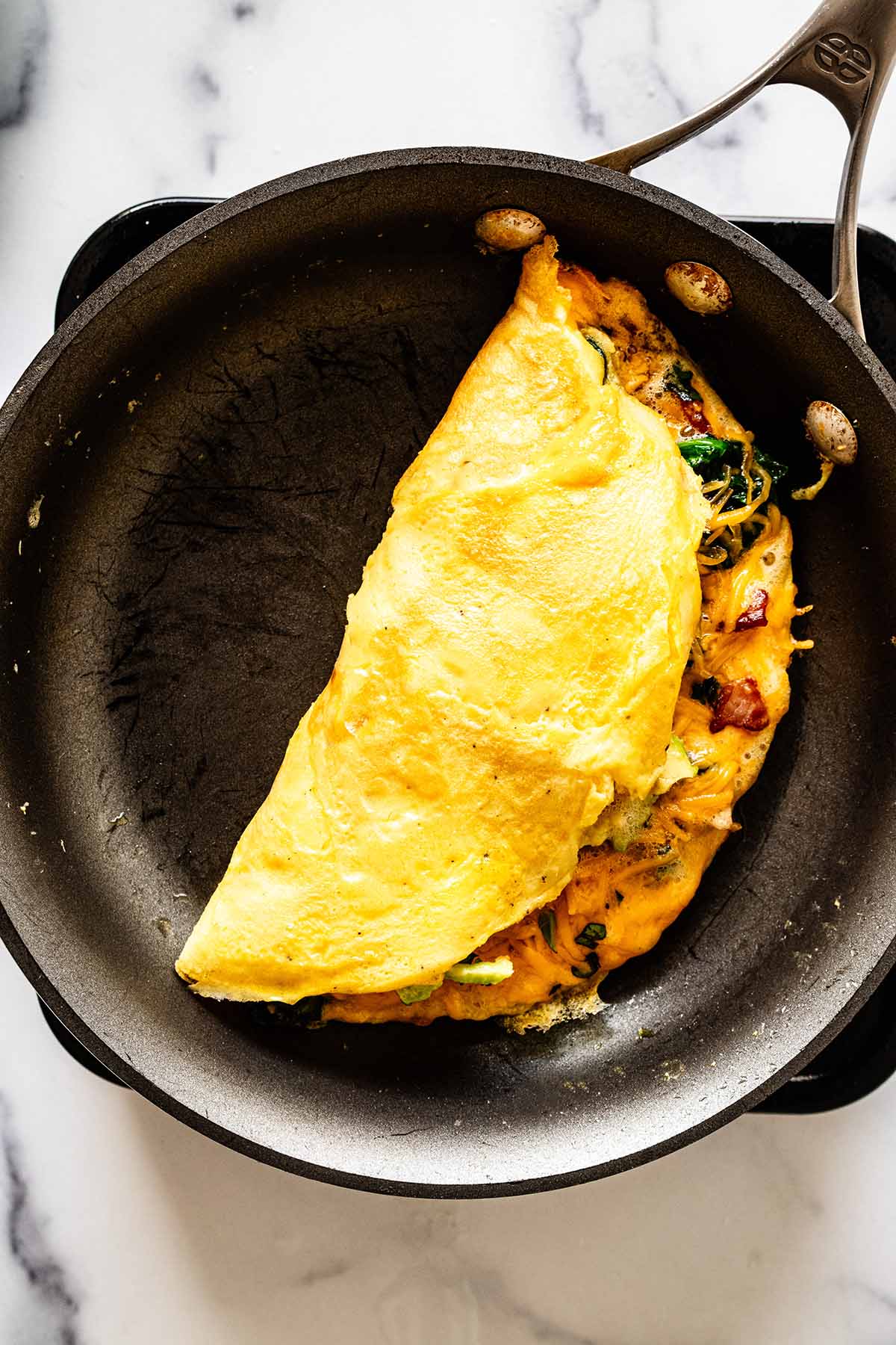 Keto omelette cooking in a skillet