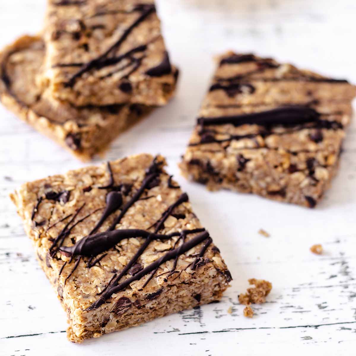 Four oatmeal bars on a distressed white wood surface