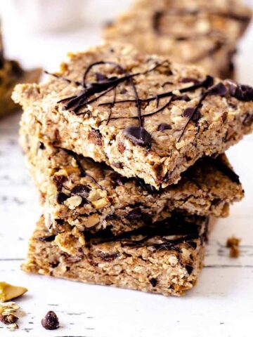 Close up of a stack of no bake oatmeal bars on a weathered white wood surface
