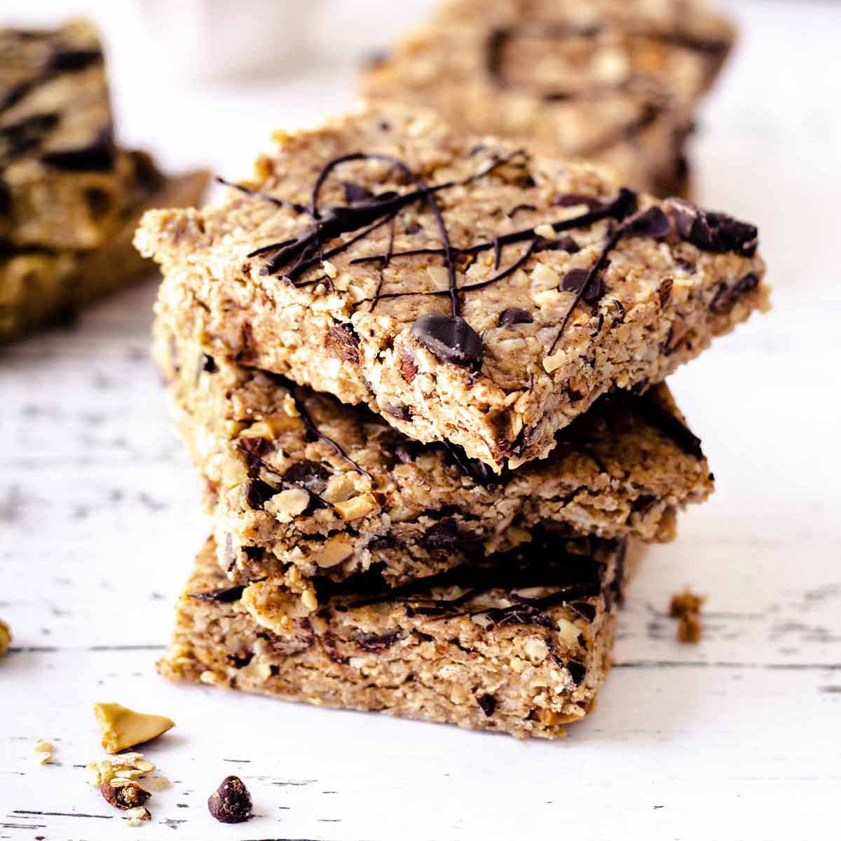 Close up of a stack of no bake oatmeal bars on a weathered white wood surface