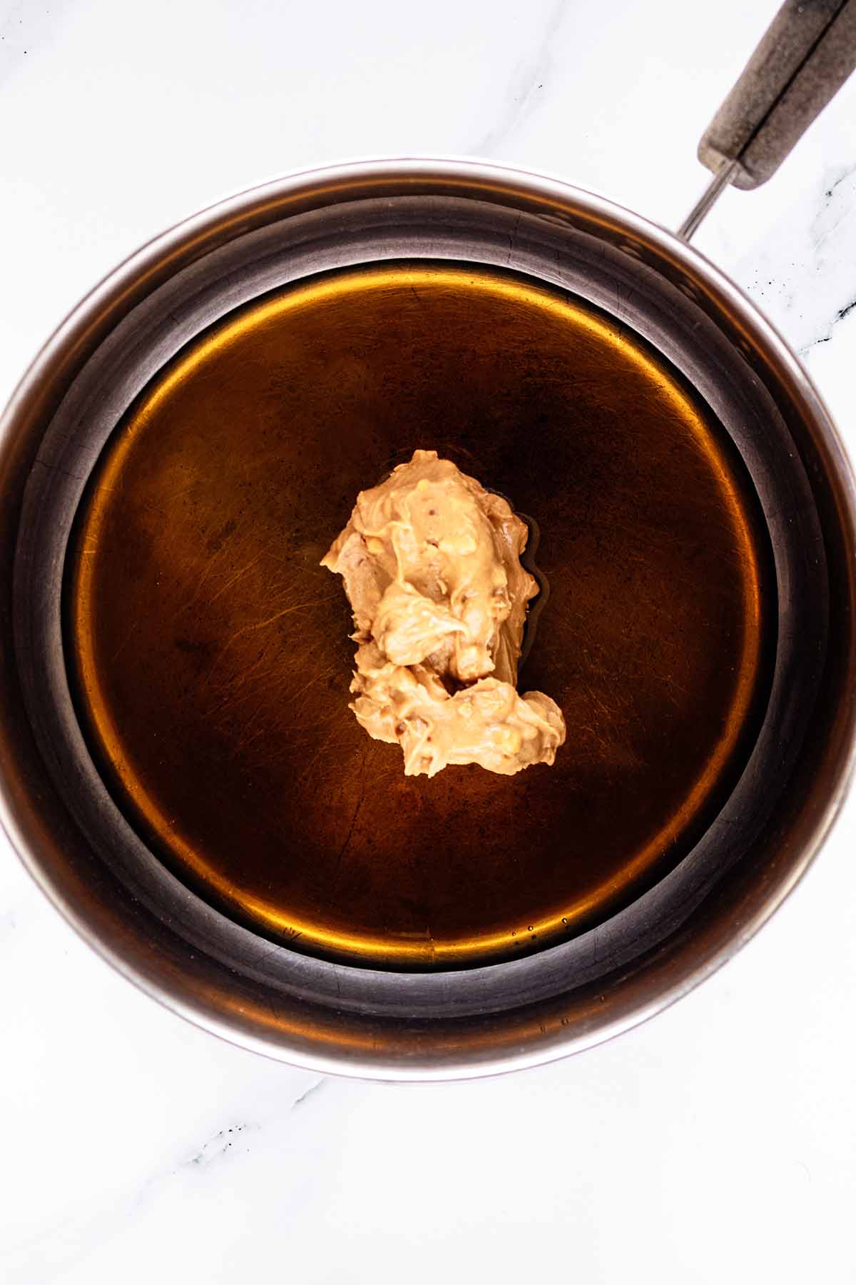 Overhead view of agave syrup and peanut butter in a saucepan