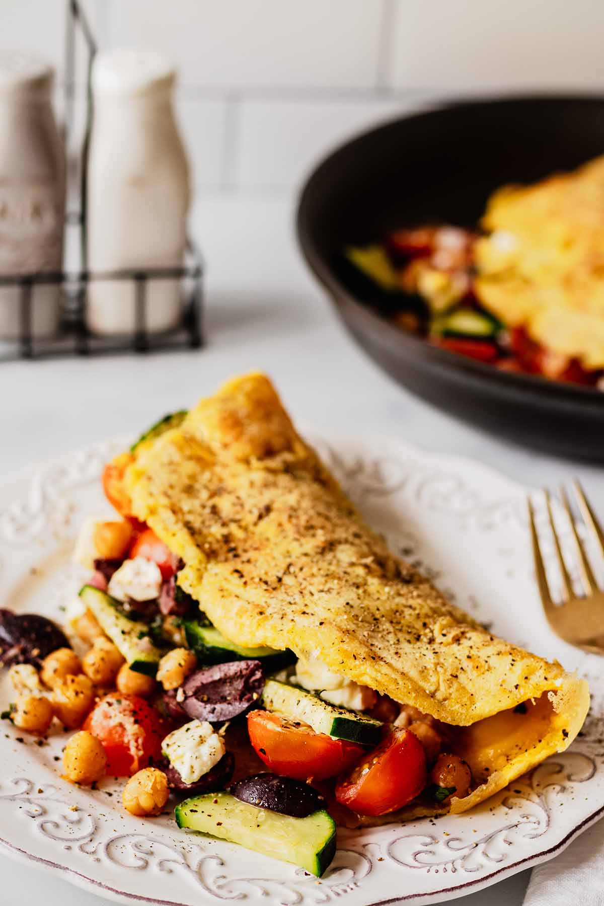 Front view of Greek omelette on a white plate with filling spilling out