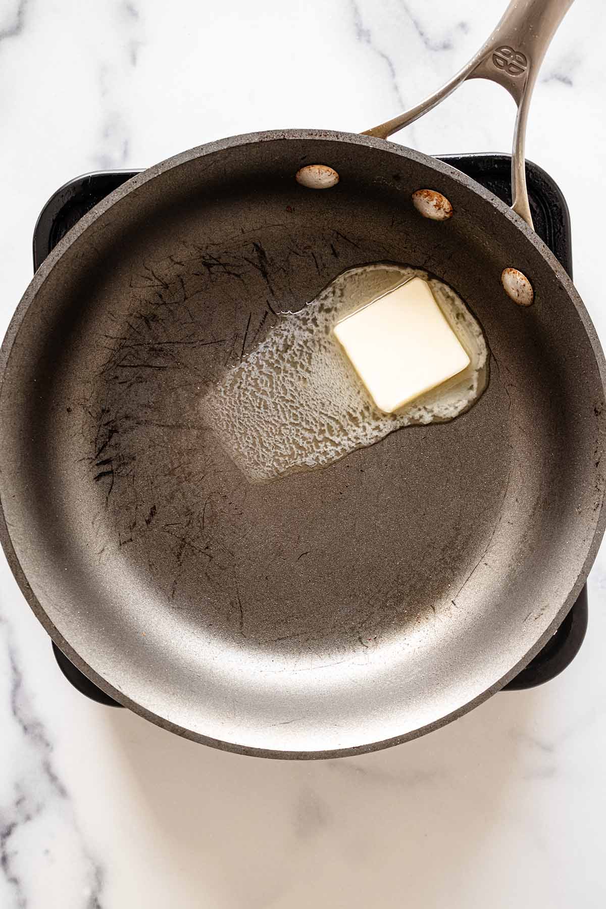 Overhead view of butter melting in a skillet