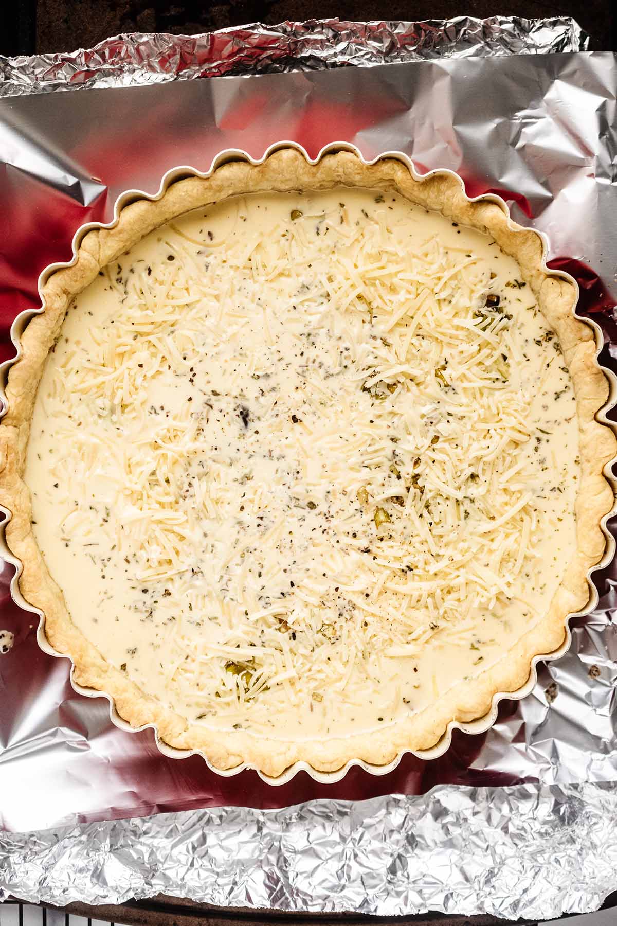 Liquid custard (eggs, milk, & cream) poured over the top of all ingredients in baked shall and tart pan.