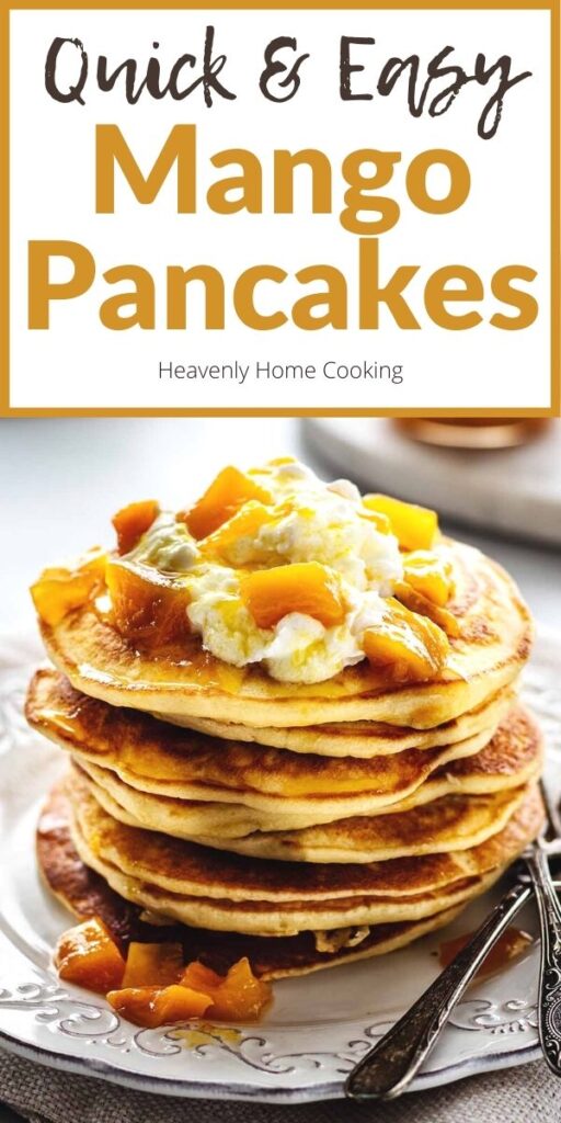 Stack of pancakes topped with whipped cream and mango compote on a white plate with two forks. A jar of fresh mango compote and hot tea in a white teacup with saucer are in the background with text overlay that says, "Quick & Easy Mango Pancakes."