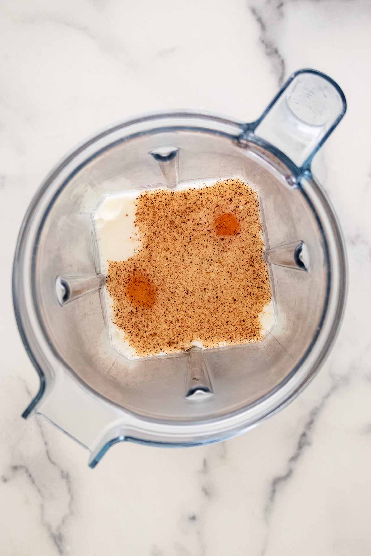 Overhead view of wet ingredients in a blender