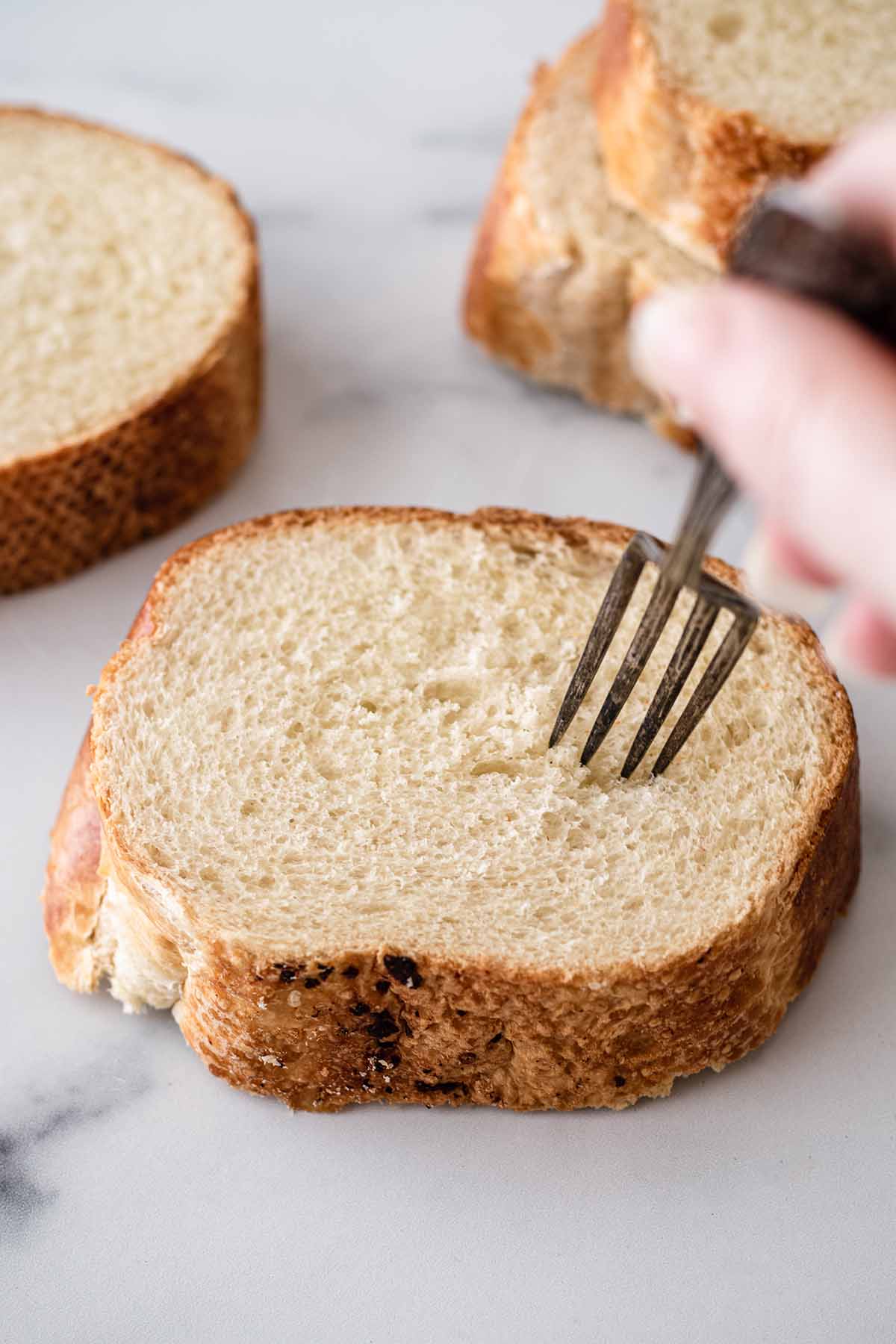 Fork poking a slice of bread.