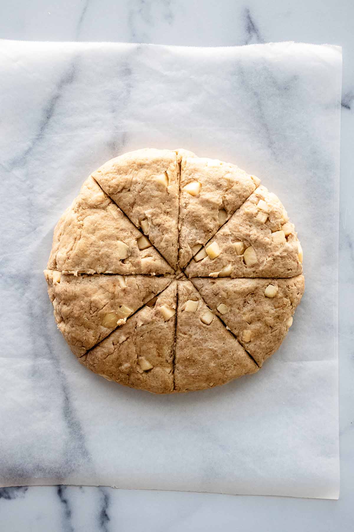 Overhead view of disc of scone dough cut into 8 triangles