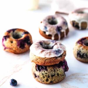 Blueberry donuts and blueberries on a marble surface