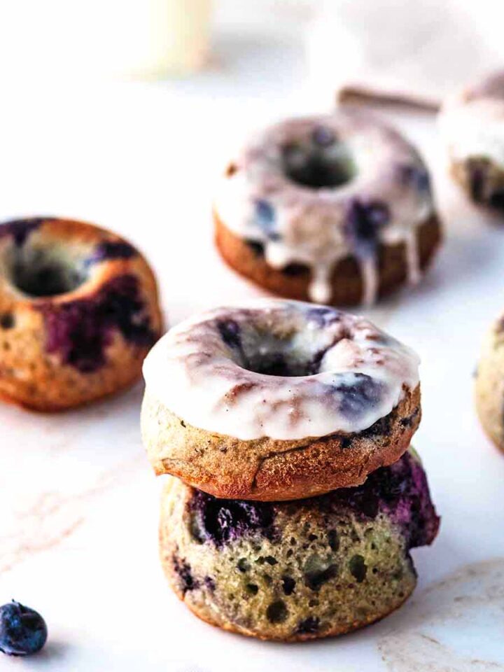 Blueberry donuts and blueberries on a marble surface
