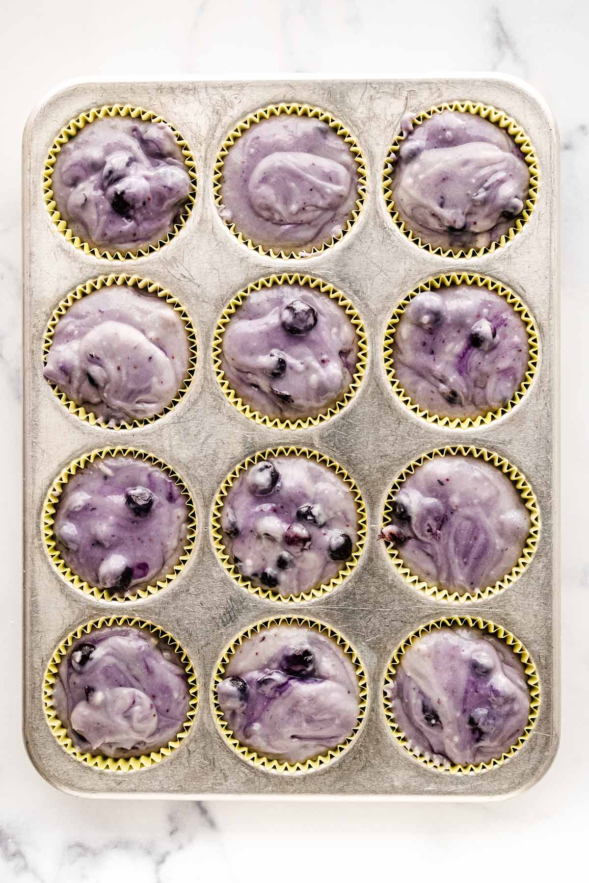 Overhead view of batter in wells in a muffin pan