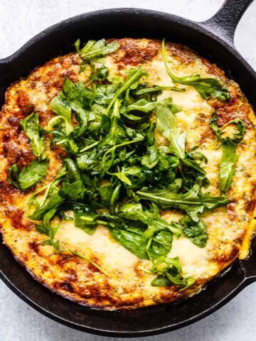 Overhead close up of ham and cheese frittata in a cast iron skillet.