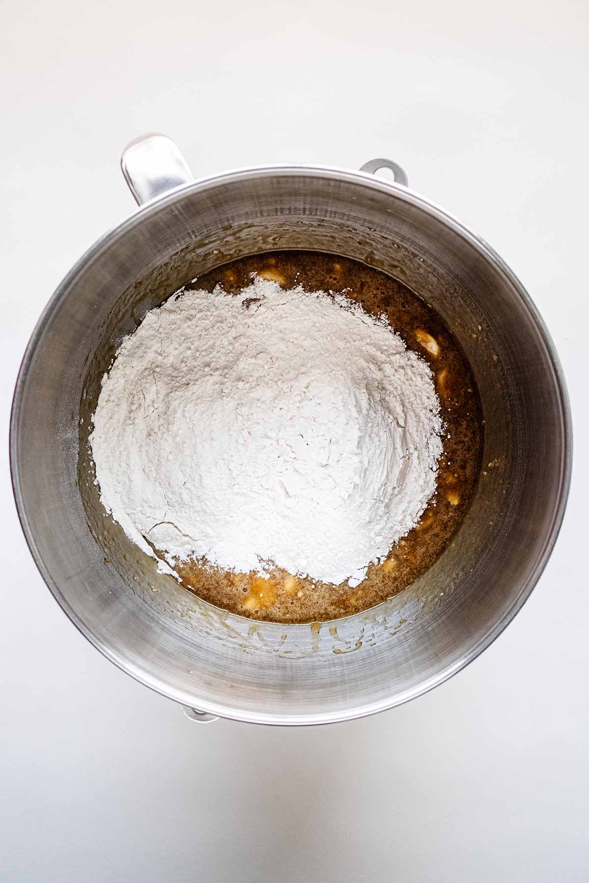 Flour with other ingredients in a stainless steel bowl.