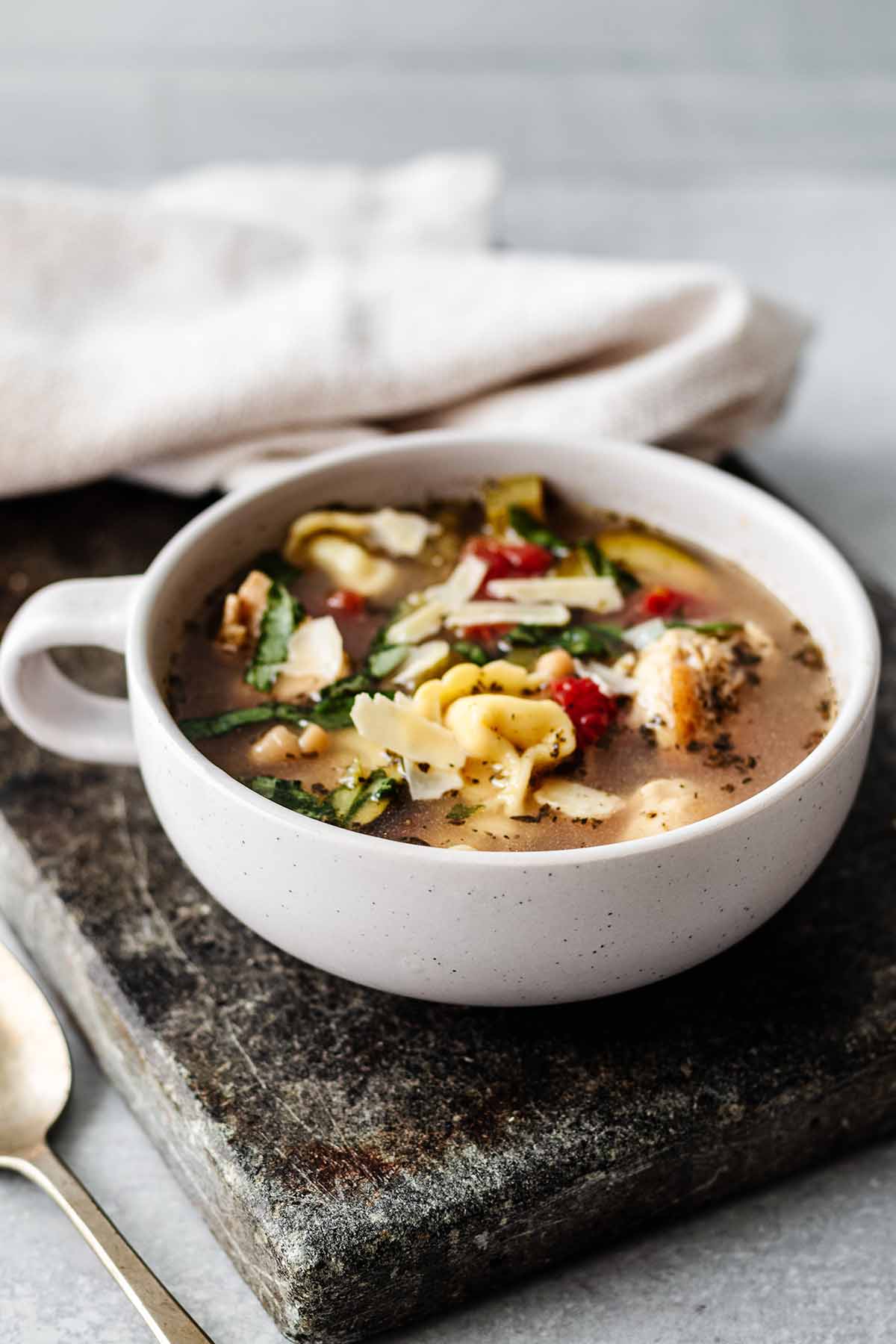 Chicken tortellini soup in a soup mug.
