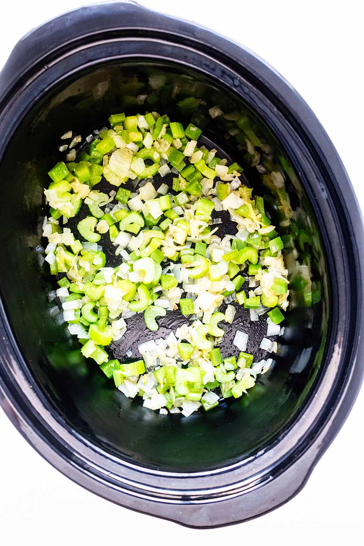 Cooked onion and celery in a slow cooker.