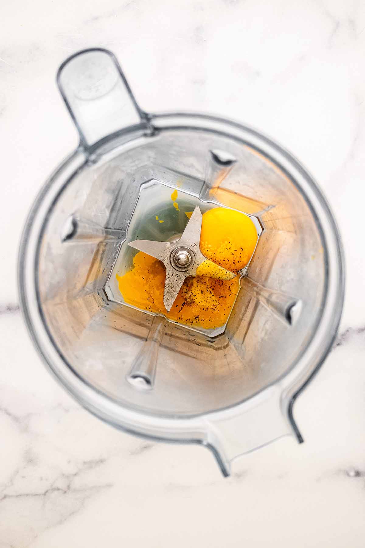 Egg yolks, lemon juice, salt, and pepper in a blender.