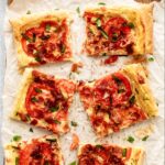 Puff pastry pizza slices on crumpled paper.
