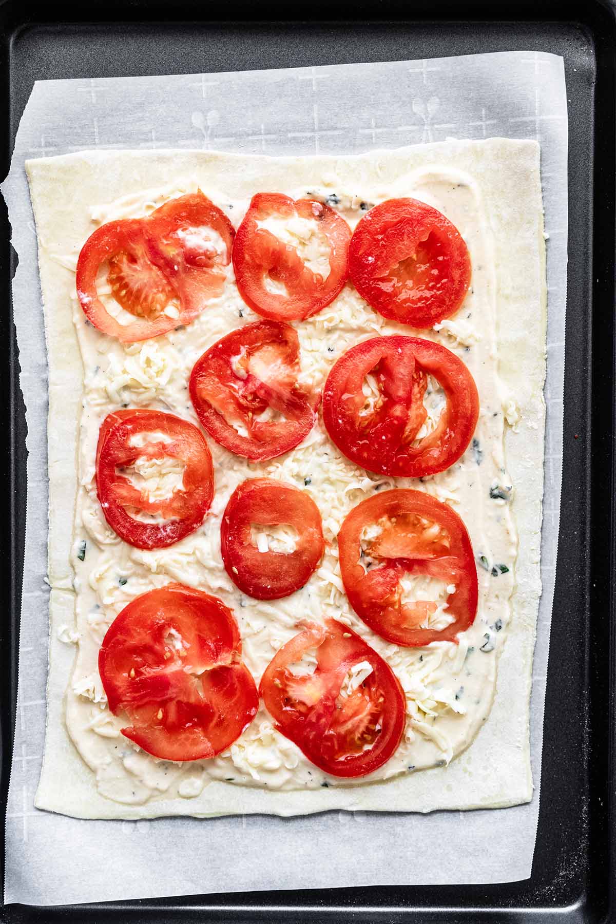 Tomato slices spread over the top of cheese.