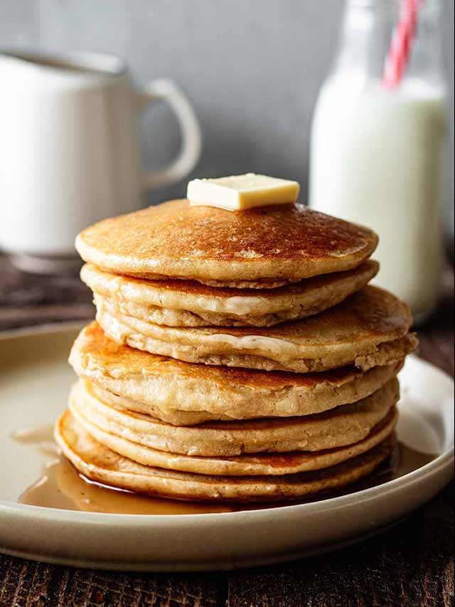 Stack of cassava pancakes on a cream plate.