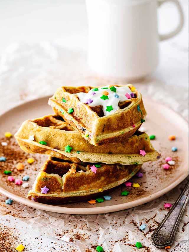 Stack of funfetti waffles on a pink plate