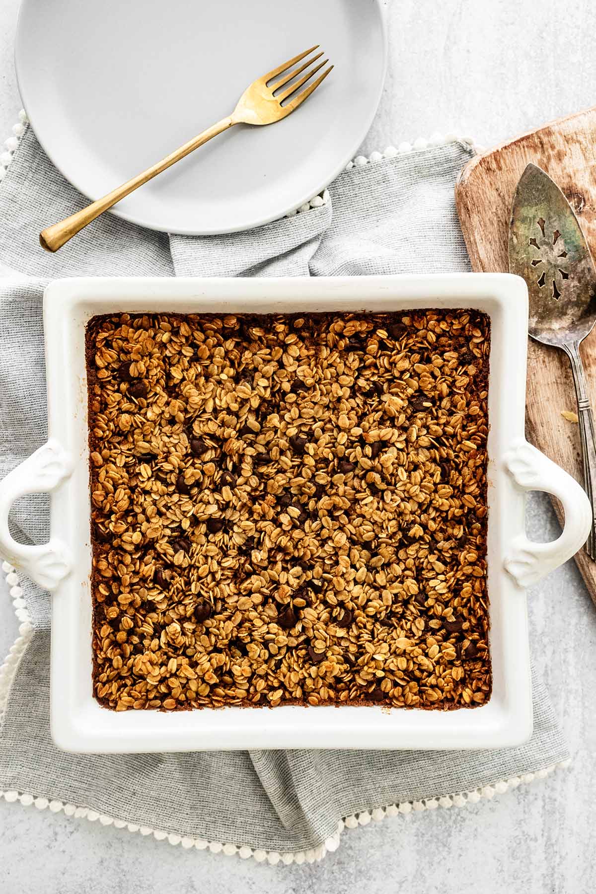 Baked oatmeal in a baking dish on a light grey napkin.