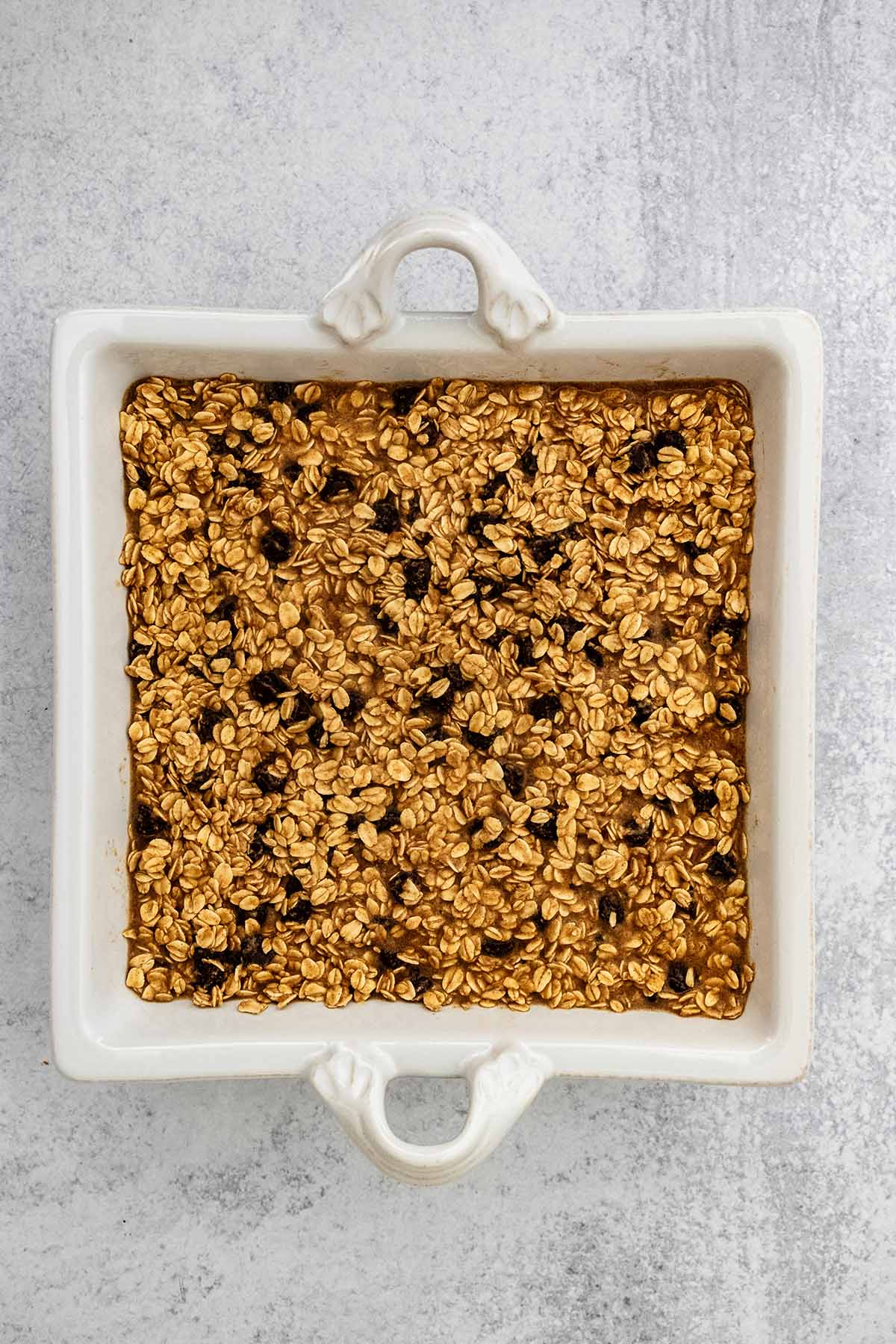 Oat mixture in a square white baking dish.
