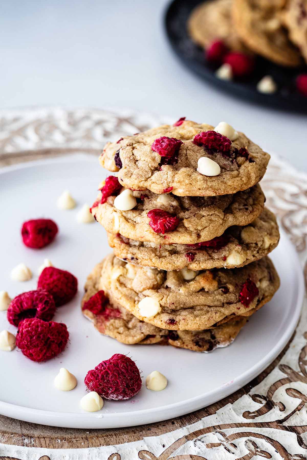 Stack of five raspberry white chocolate on a white plate with raspberries and white chocolate chips.