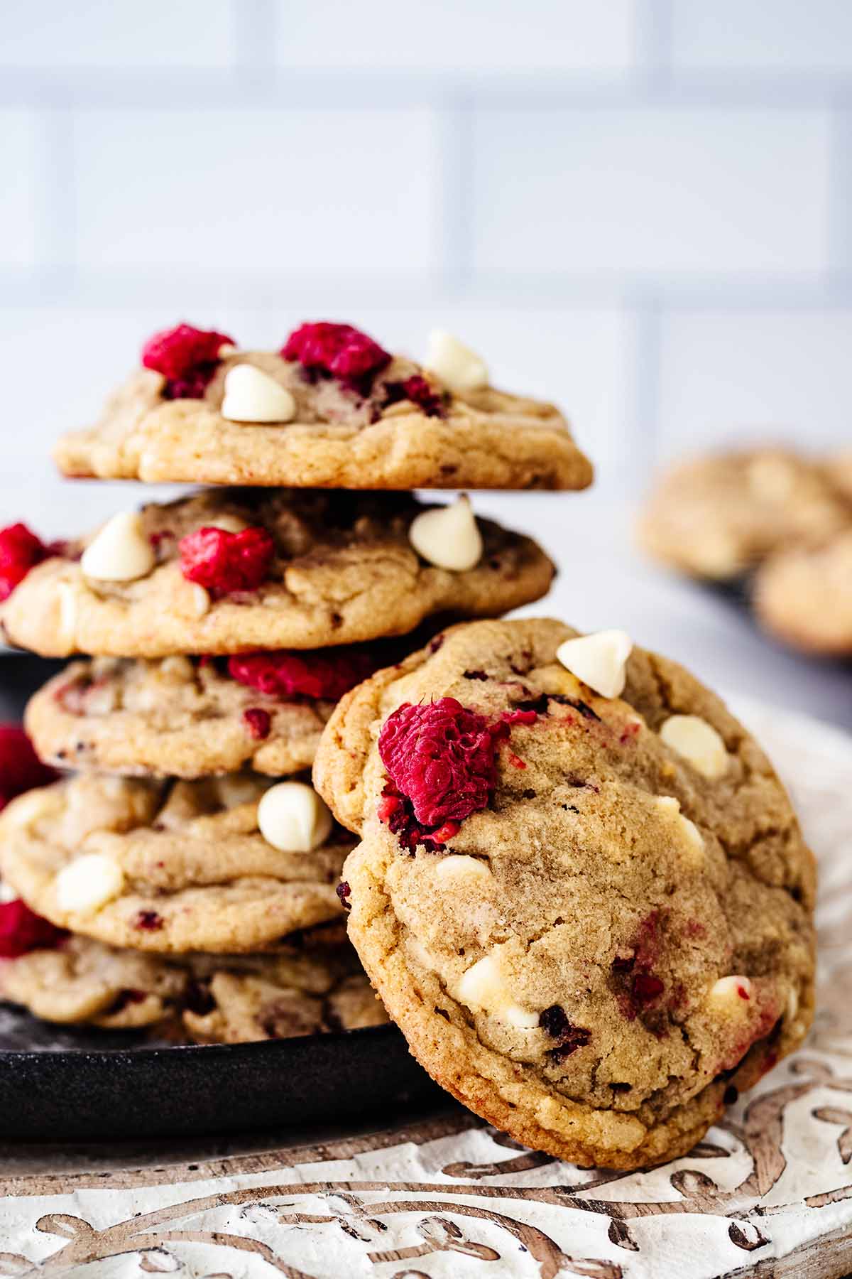Stack of five raspberry white chocolate cookies with a cookie leaning against the stack.
