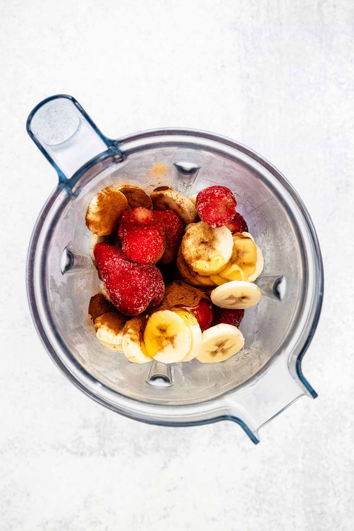Strawberry banana smoothie bowl ingredients in a blender.