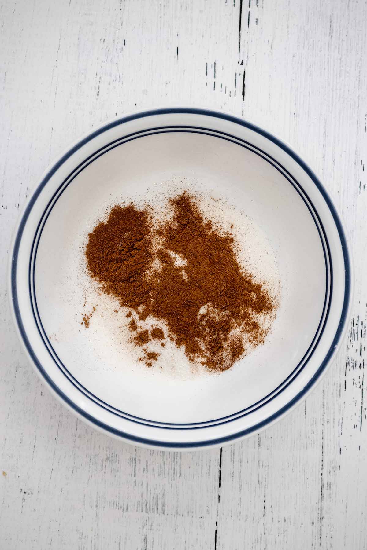 Granulated sugar and cinnamon in a small white bowl.