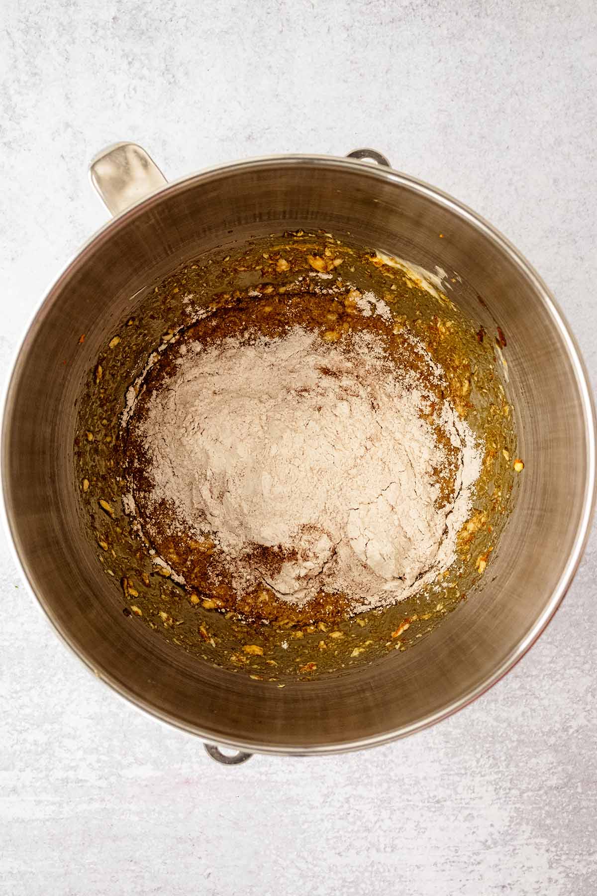 Dry mixture on top of wet mixture in a large metal mixing bowl.