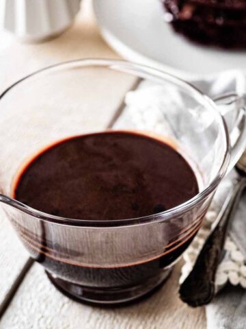 Chocolate pancake syrup in a small glass pitcher.