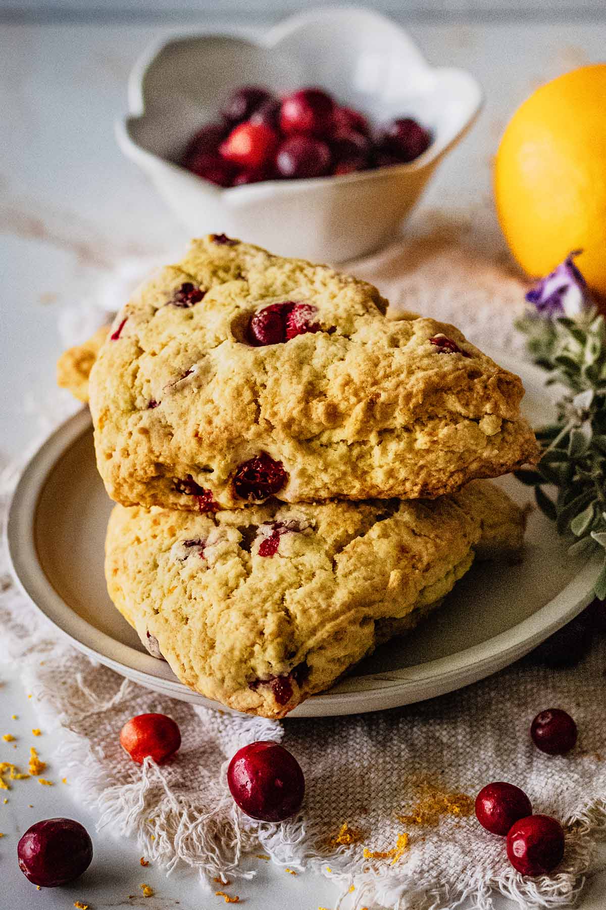 Short stack of orange blueberry scones on a light gray plate.