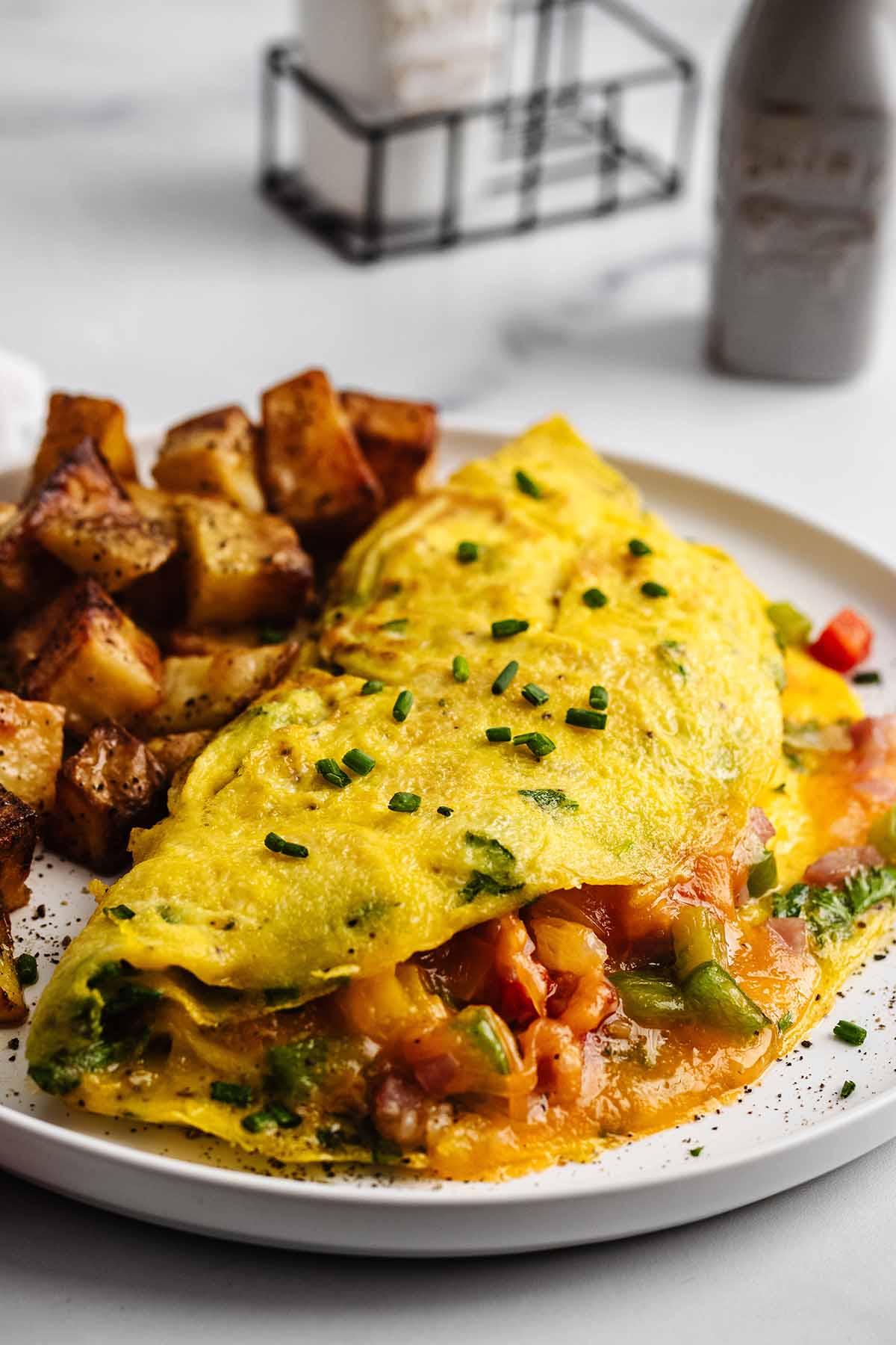 Close up of a Western omelette and roasted potatoes on a white plate.
