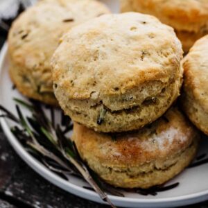Close up of rosemary biscuits on a white plate.
