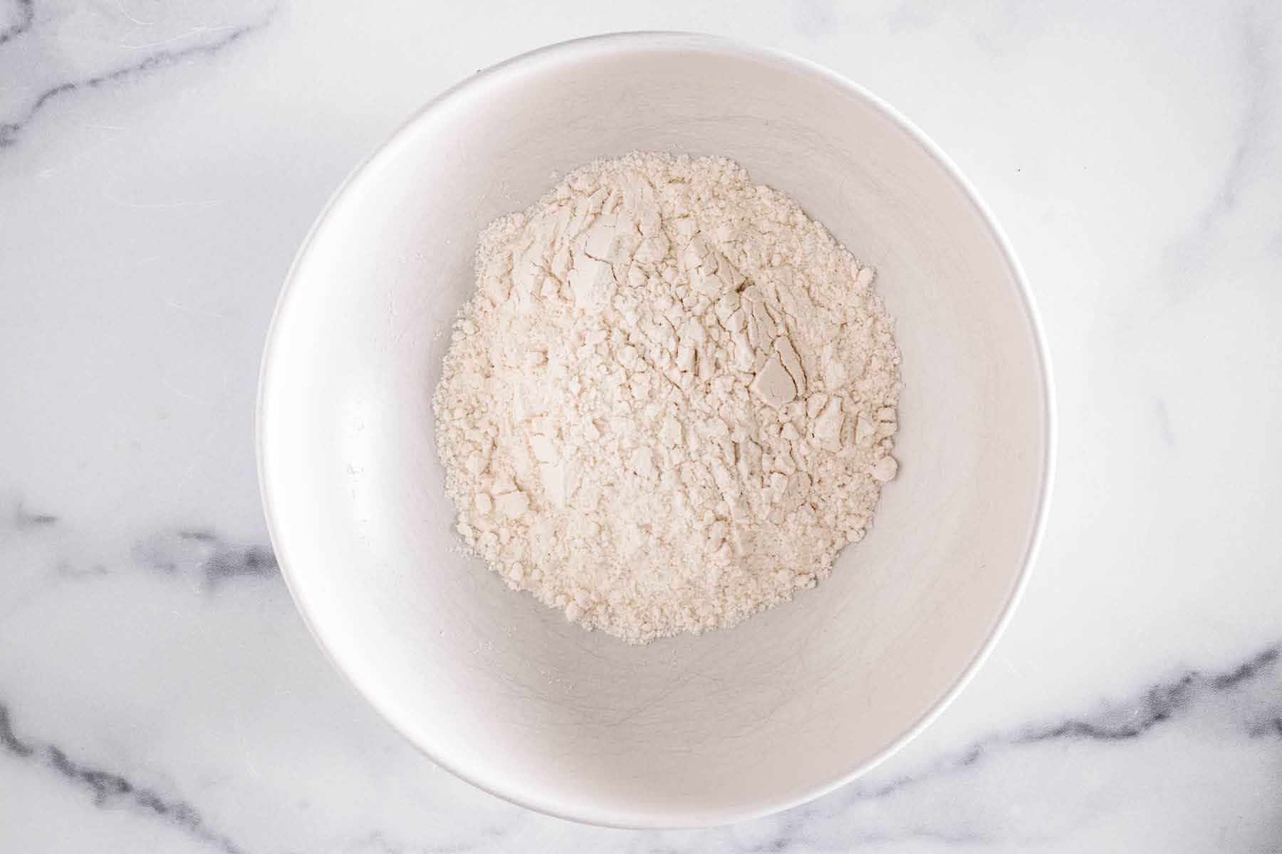 All purpose flour in a white bowl.