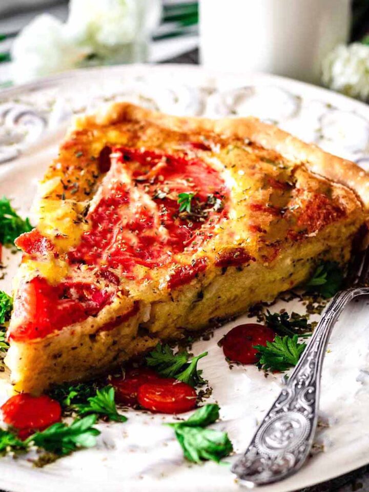 Serving of Italian quiche on a white plate with a fork