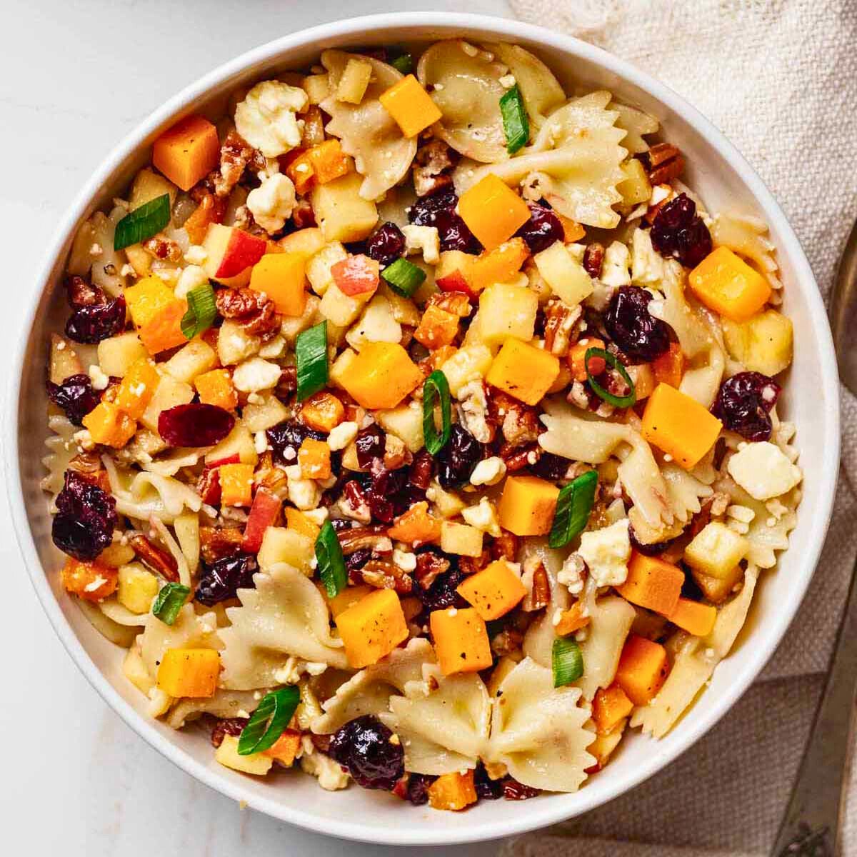 Overhead view of autumn pasta salad in a white serving bowl
