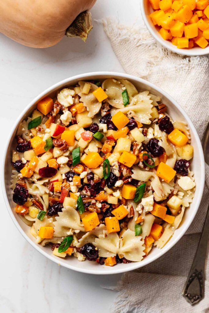 Overhead view of autumn pasta salad in a white serving bowl