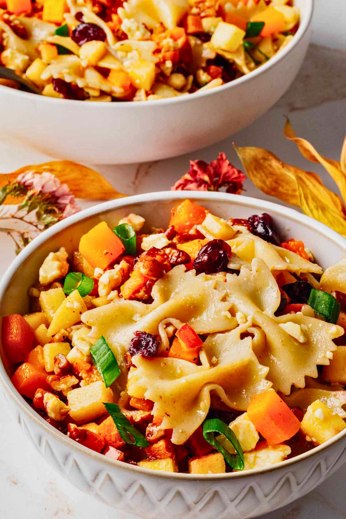 Close up of a serving of autumn pasta salad in a white bowl