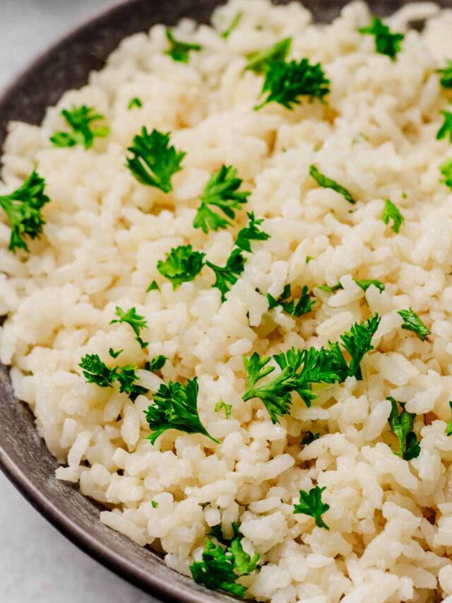 Fluffy Garlic Parmesan Rice served in a dark bowl, topped with fresh parsley for a pop of color and flavor.