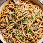 Creamy one-pot mushroom pasta in a skillet, topped with sliced mushrooms and fresh parsley.