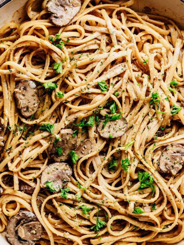 Creamy one-pot mushroom pasta in a skillet, topped with sliced mushrooms and fresh parsley.
